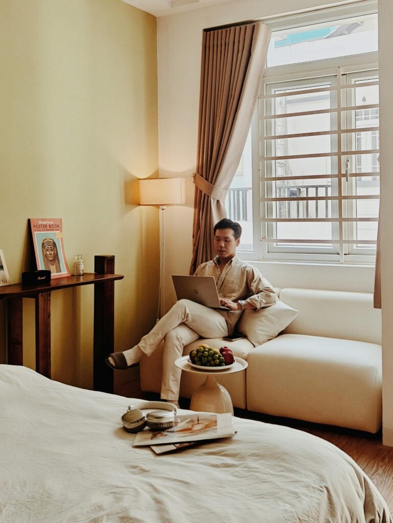 pexels photo 32598413 32598413 A cozy Airbnb room in Vietnam with a man relaxing and working on a laptop, creating a serene atmosphere.